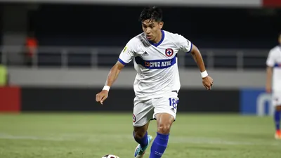 A tight action crop of a young, anonymous midfielder in a Cruz Azul jersey, sprinting down the wing with the ball at his...