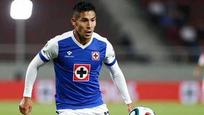 A tight action crop of an anonymous Cruz Azul player in a blue and white jersey with white sleeves and a white collar...