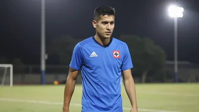 A 25-year-old Cruz Azul player, with a lean build and short hair, wearing a solid blue jersey, photographed with an 85mm...
