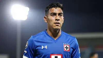 A waist-up photo of a Cruz Azul player, aged 25-30, with a determined expression, wearing a solid blue jersey, taken with...