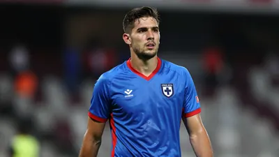 Mid-shot of a 27-year-old anonymous goalkeeper, muscular build, waist-up, wearing Cruz Azul home kit - blue shirt with...