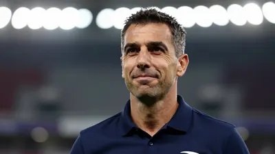 Photorealistic head-and-shoulders of a mid-40s male sporting director in a solid navy blue polo, celebrating with a...