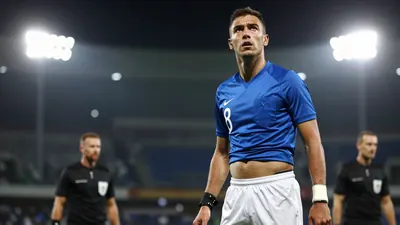 A tight action crop of a midfielder in a blue jersey with white shorts, number 8 on the back, looking up to the referee...